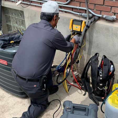 Technician using a testing device for Air Conditioning Maintenance in Lindon, UT.